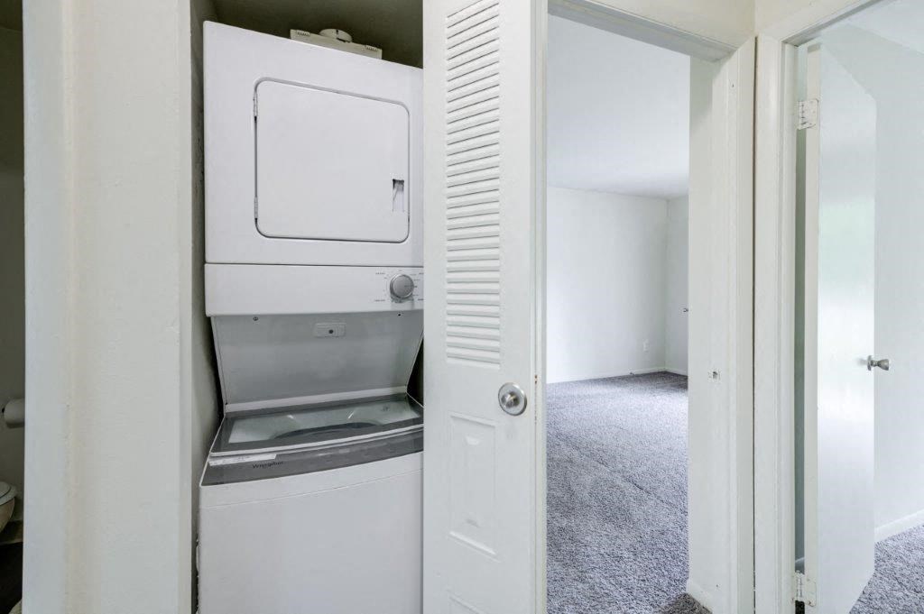 a white washer and dryer in a white closet