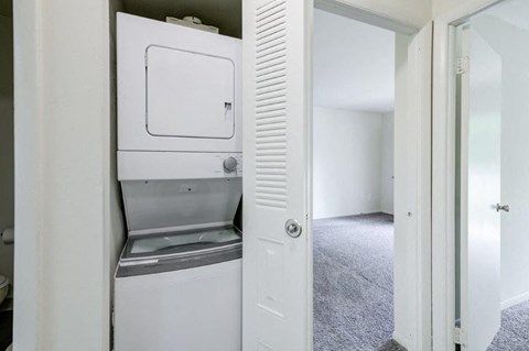 a white washer and dryer in a white closet