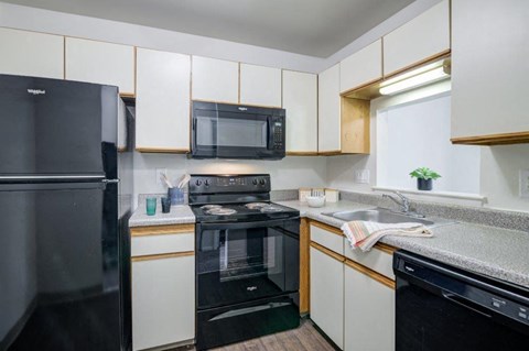 a kitchen with black appliances and white cabinets