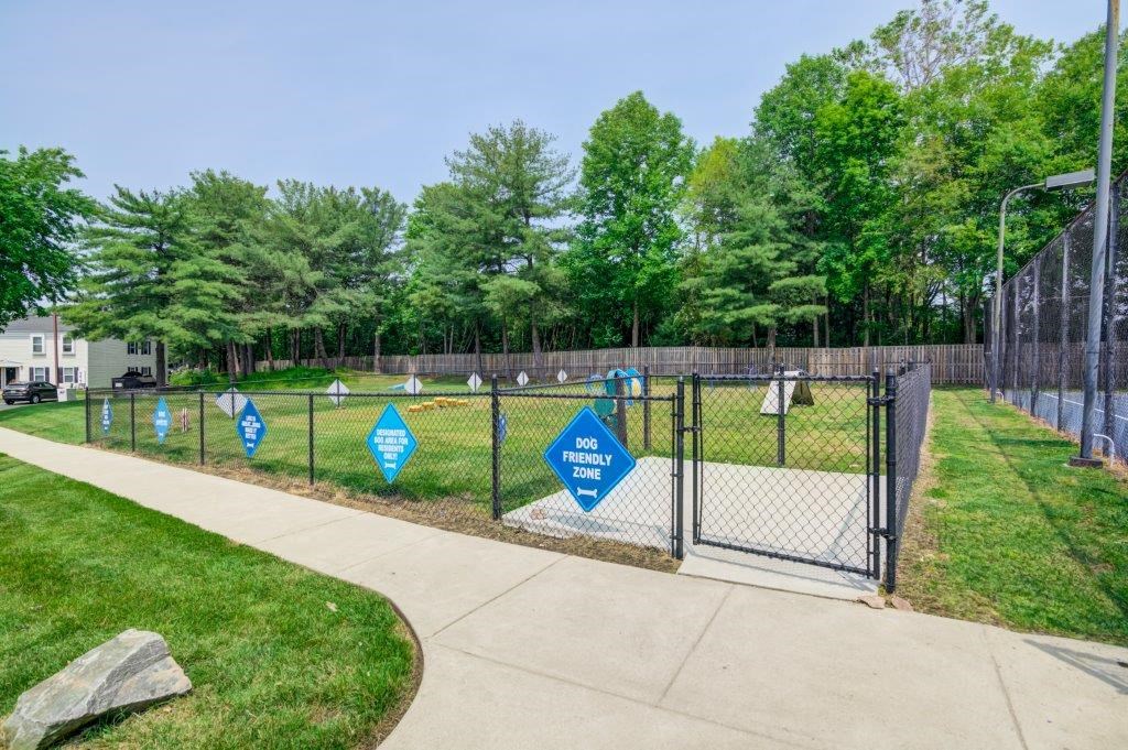 a fenced in dog park with blue signs on the fence