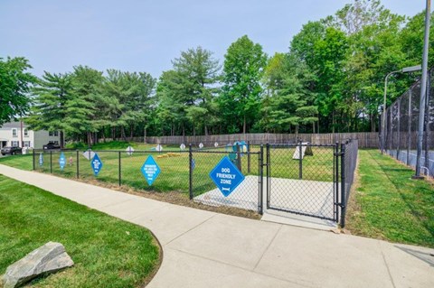 a fenced in dog park with blue signs on the fence