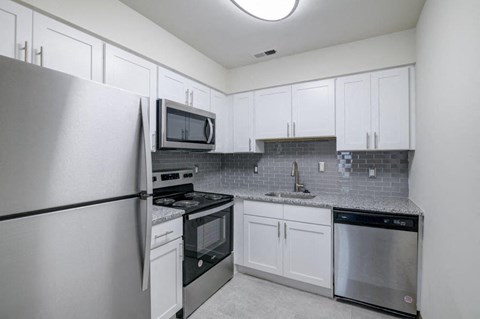 a kitchen with stainless steel appliances and white cabinets