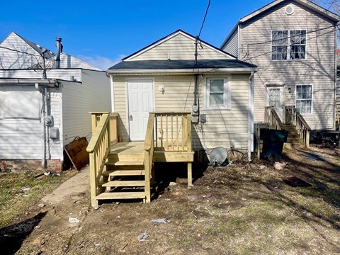 A small house with a wooden deck in front.
