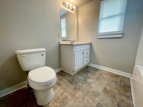 A white toilet sits next to a sink in a small bathroom.