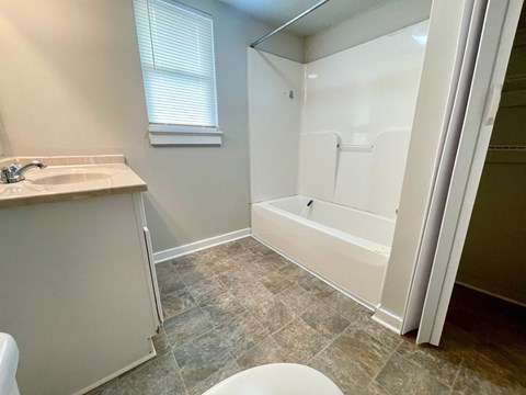 A white bathroom with a sink, toilet, and bathtub.