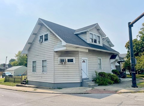 A two-story house with a white door and a small porch.