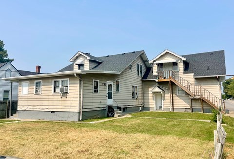 A house with a grey siding and a brown roof.