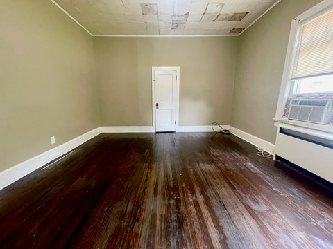 A room with wooden floors and a white door.