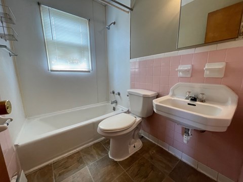 A white toilet sits next to a white sink in a bathroom.