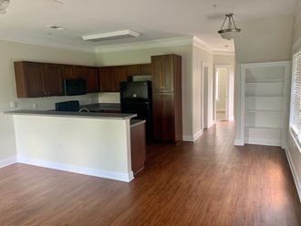 an empty kitchen and living room with wood flooring and