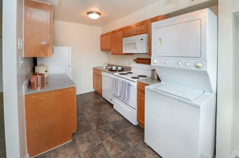 a kitchen with white appliances and wooden cabinets