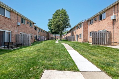 our apartments are located in a quiet area with a lawn and a tree