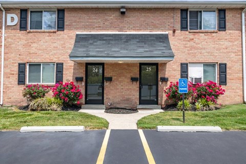 a brick building with a porch and a blue parking sign