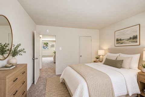 A bedroom with a large bed and a painting on the wall.