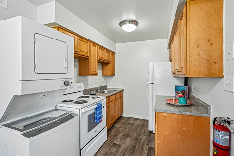 A kitchen with white appliances and wooden cabinets.