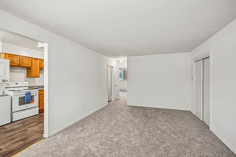 A spacious, empty room with a kitchen area to the left.