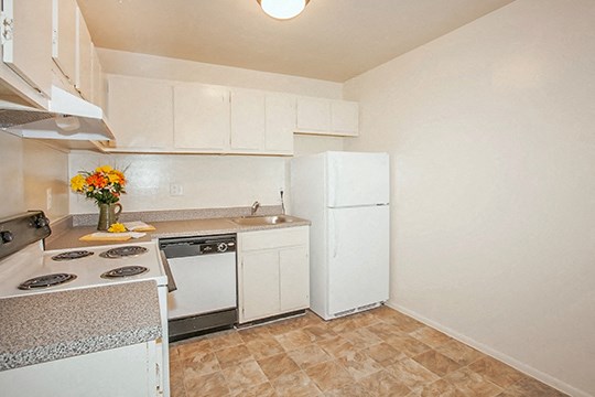 a kitchen with white appliances and a refrigerator