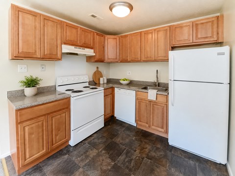 A kitchen with wooden cabinets and a white refrigerator.