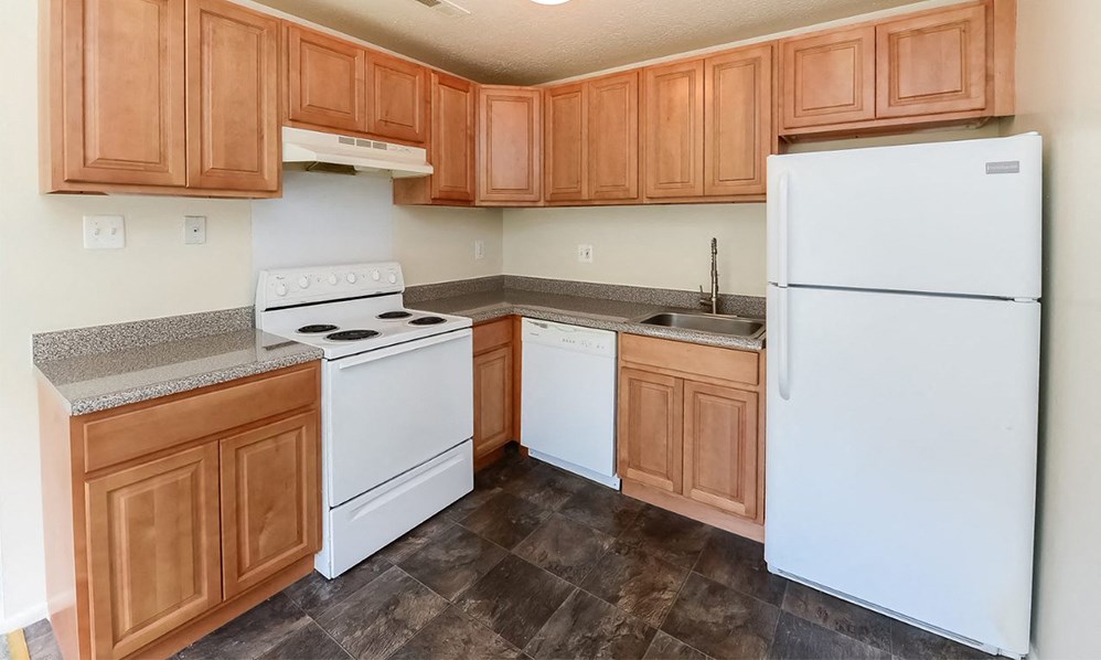a kitchen with white appliances and wooden cabinets