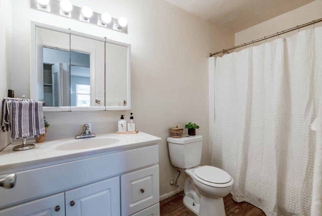 a bathroom with a toilet and a sink and a mirror