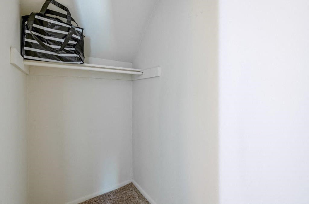 a small room with a white wall and a shelf