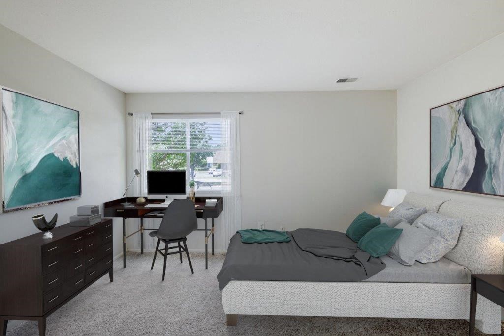 a bedroom with a bed and a desk with a computer