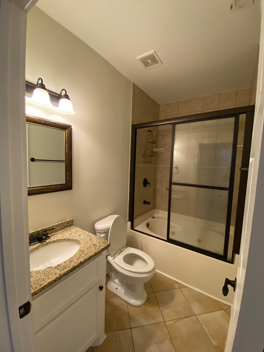 A bathroom with a toilet, sink, and mirror.