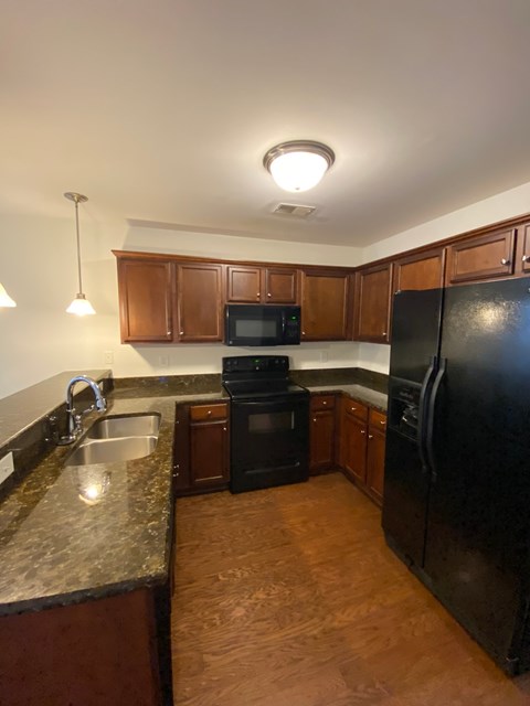 a kitchen with black appliances and granite counter tops