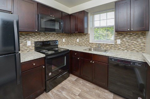 a kitchen with a stove and a sink and a microwave