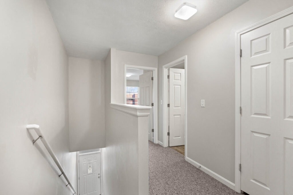 the landing of a home with white walls and white doors