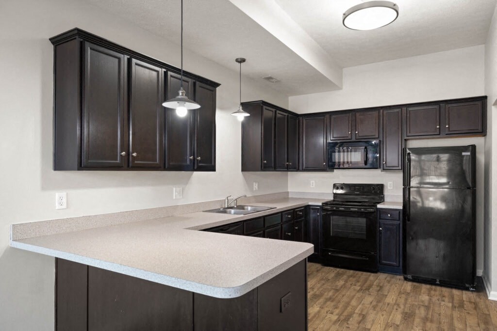 a kitchen with black appliances and white counter tops