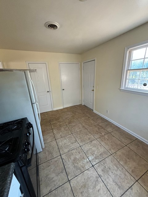 A kitchen with a black stove top oven and white cabinets.
