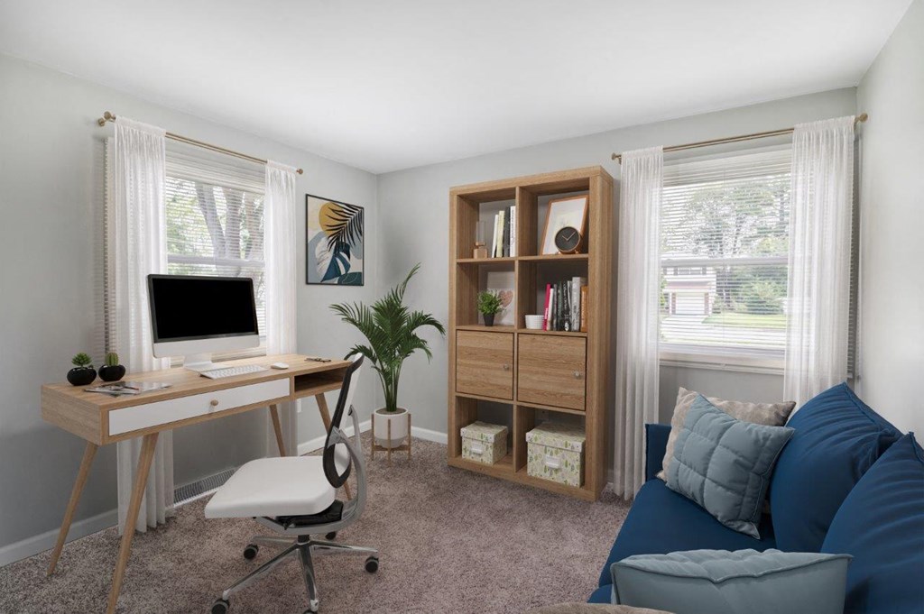 a home office with a computer and a couch