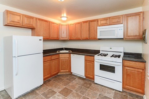 a kitchen with white appliances and wooden cabinets