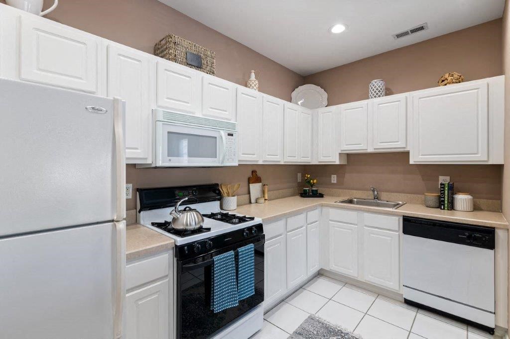 a white kitchen with a stove and a refrigerator