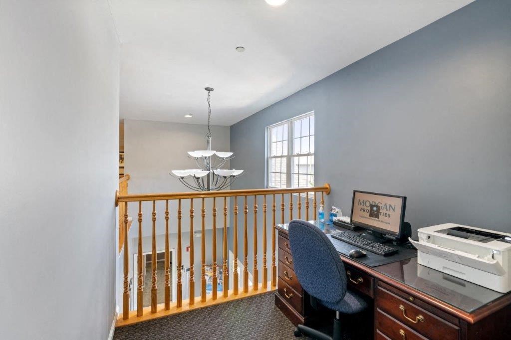 a loft with a desk and a computer      and a window
