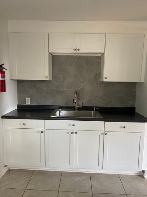 a kitchen with white cabinets and a sink