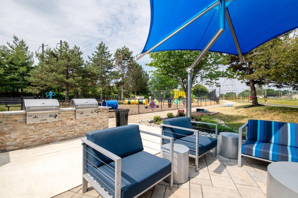 Outdoor seating area with 2 built-in grills in the background