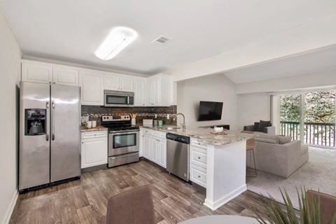 kichen with modern white cabinets, stainless steel appliances, and granite countertops