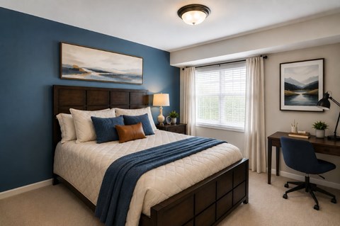 A bedroom with a large bed and a desk with a chair.