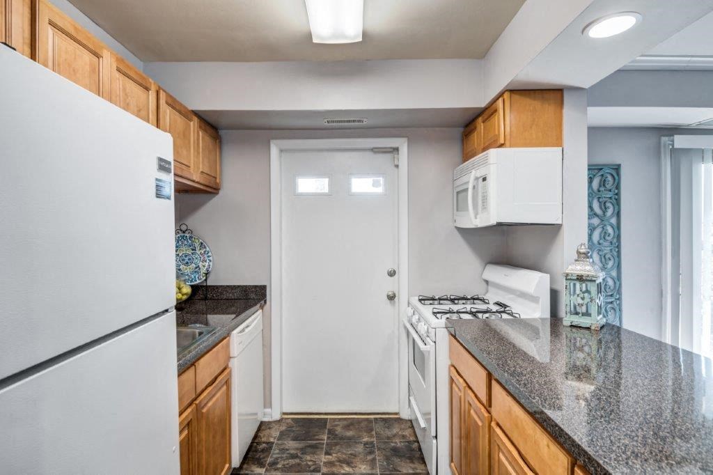 a kitchen with a white refrigerator and a sink