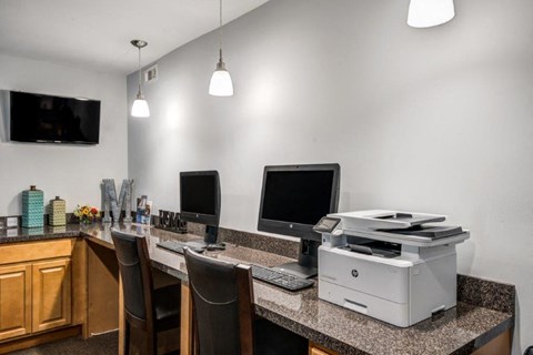 a office with a printer and computers on a counter