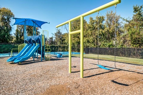 our children s playground is equipped with a swing set and a slide