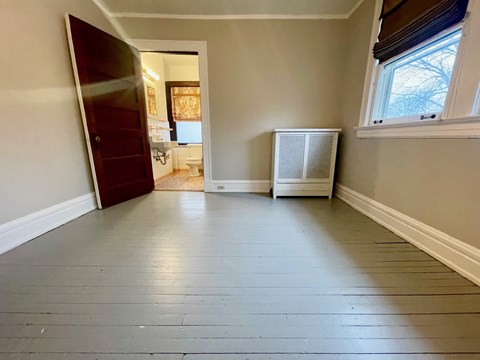 A room with a wooden floor and a window.