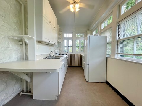 A kitchen with white appliances and a large island.