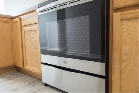 a white oven in a kitchen with wooden cabinets