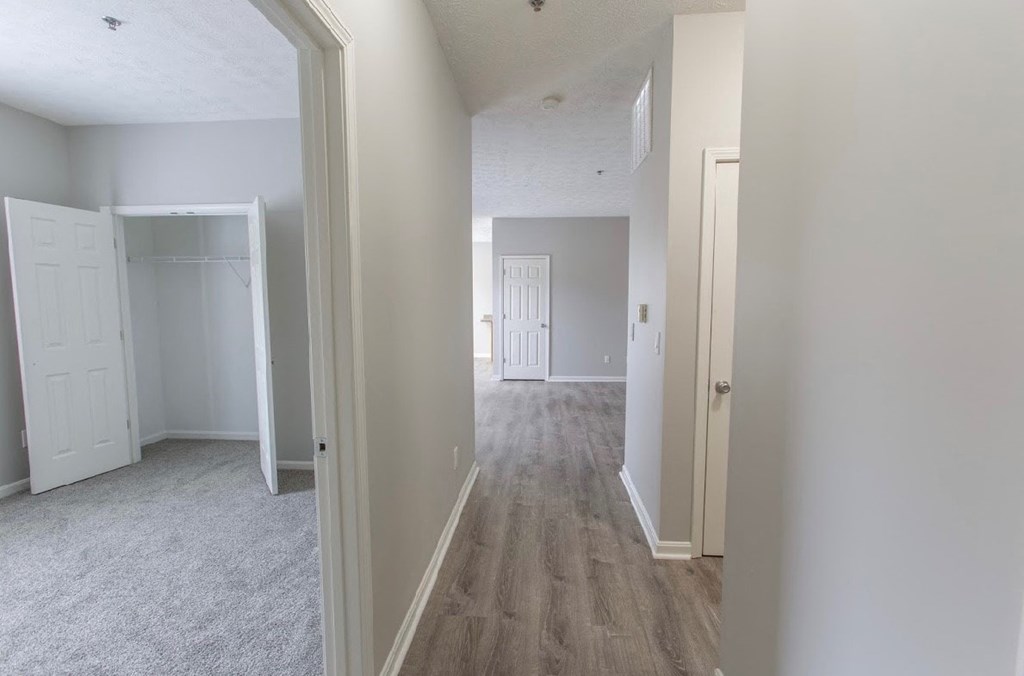 an empty bedroom with white walls and wood flooring