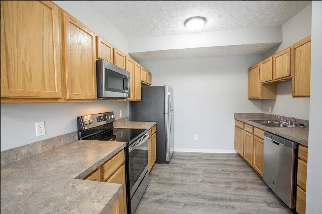 a kitchen with wooden cabinets and stainless steel appliances