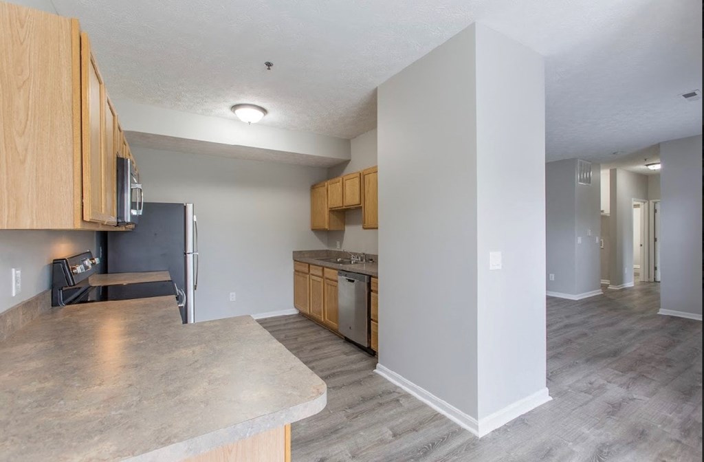 an empty kitchen with wooden cabinets and stainless steel appliances