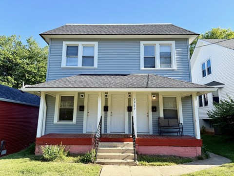 A two-story house with a red garage door and a white front door.
